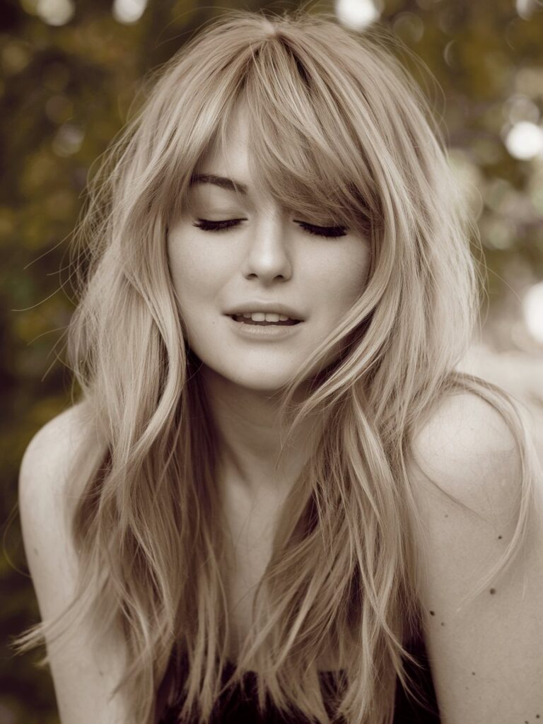 8. Romantic Waves: Long Layers with Bardot-Inspired Bangs